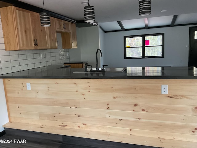 kitchen with backsplash, decorative light fixtures, and sink