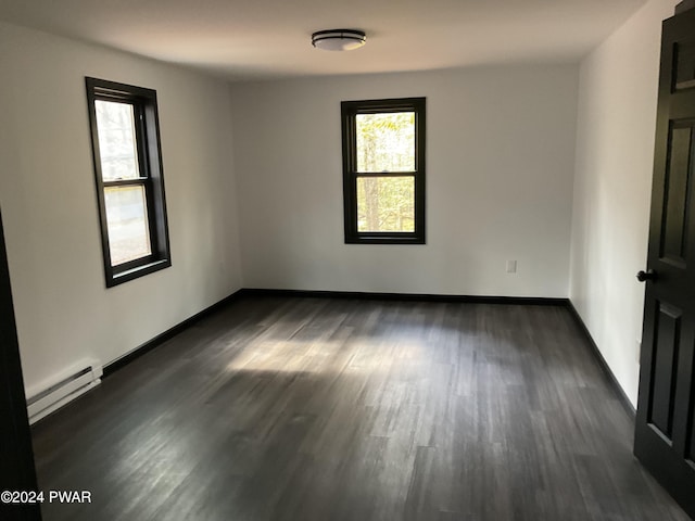 unfurnished room featuring dark hardwood / wood-style flooring and a baseboard radiator