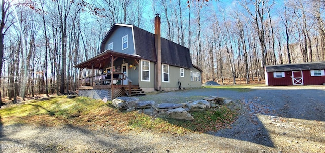 view of front of home with a storage unit and covered porch