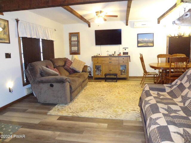 living room featuring ceiling fan, wood-type flooring, a wall unit AC, and beamed ceiling