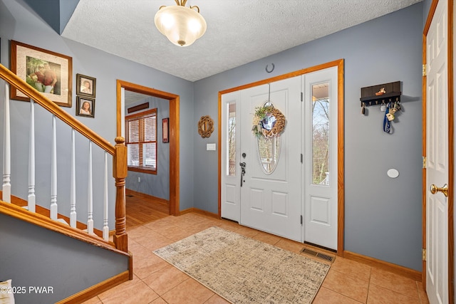 216 Comstock Dr, Lords Valley, PA 18428 - foyer with tile patterned floors, stairway, and a textured ceiling