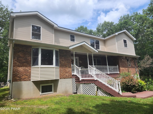 216 Comstock Dr, Lords Valley, PA 18428 - view of front of home featuring brick siding, covered porch, and a front yard