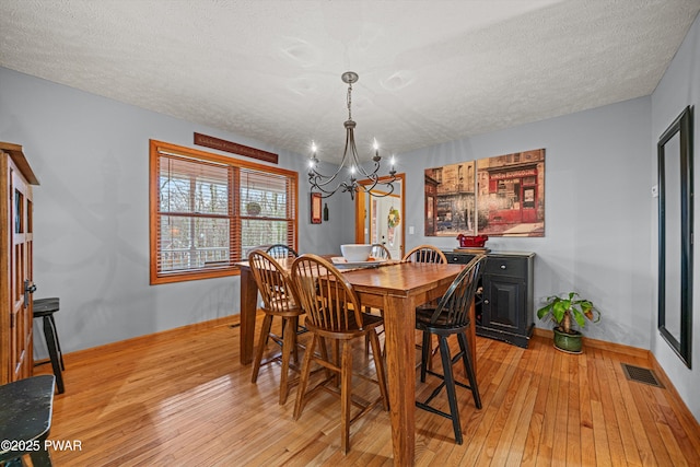 216 Comstock Dr, Lords Valley, PA 18428 - dining space with a chandelier, light wood-type flooring, and a textured ceiling