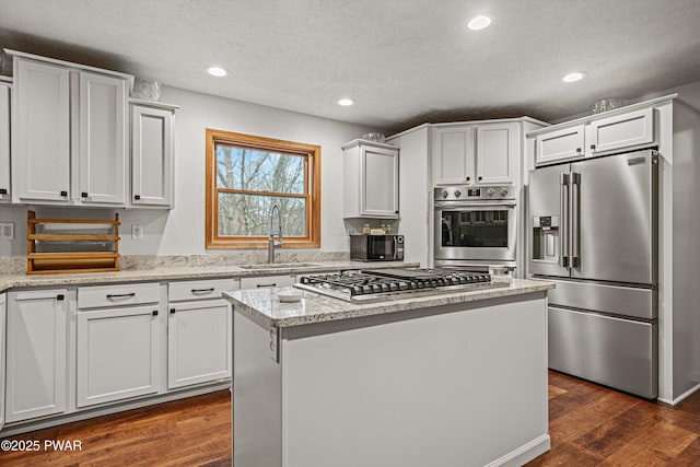 216 Comstock Dr, Lords Valley, PA 18428 - kitchen featuring stainless steel appliances, a textured ceiling, dark wood-style floors, a kitchen island, and white cabinetry