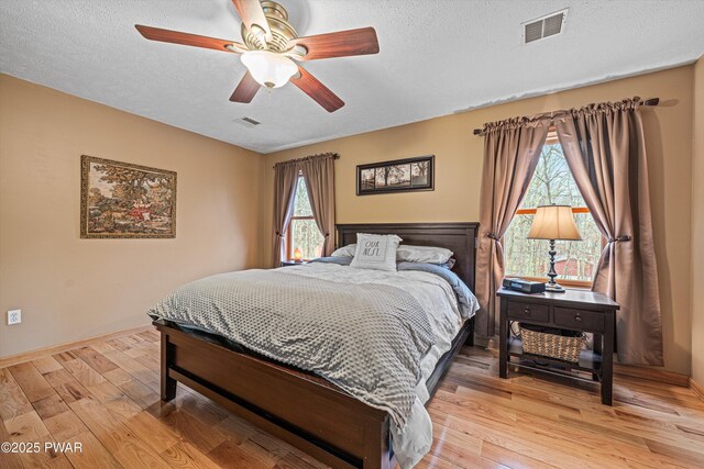 216 Comstock Dr, Lords Valley, PA 18428 - bedroom with multiple windows, light wood-style floors, a textured ceiling, and ceiling fan