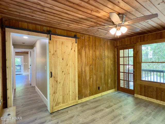 17 Applegate Rd, Lake Ariel, PA 18436 - empty room with a barn door, wood finished floors, wood ceiling, baseboards, and wooden walls