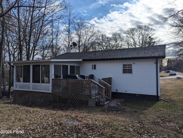 rear view of house with a sunroom and a deck