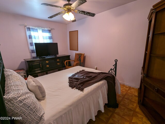 bedroom with ceiling fan and parquet floors