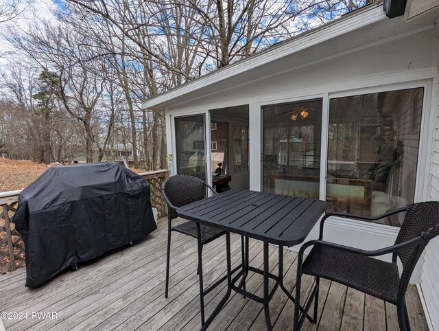 wooden terrace featuring a sunroom and grilling area