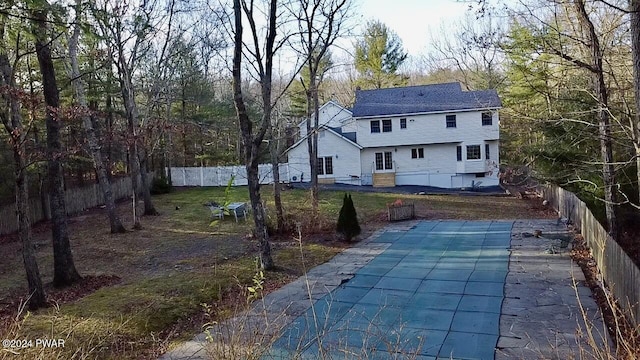 rear view of house with a patio area and a covered pool