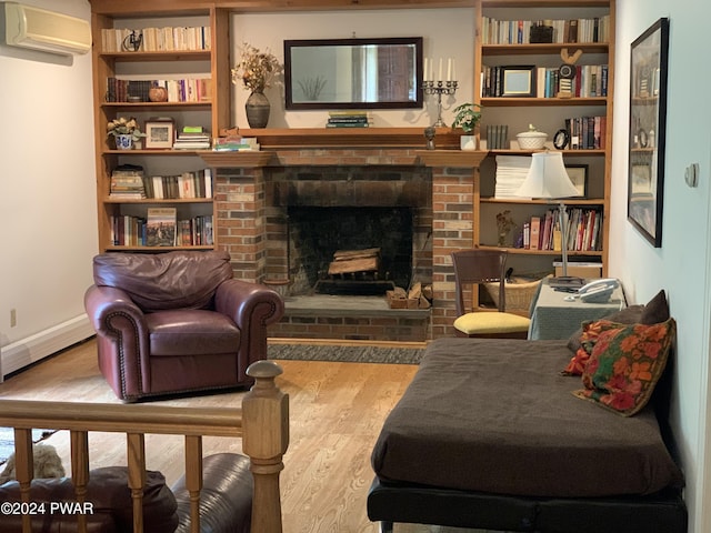 sitting room with a wall mounted air conditioner, baseboard heating, a fireplace, and hardwood / wood-style floors