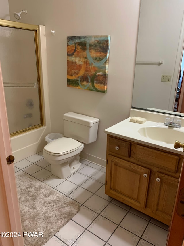 full bathroom with tile patterned flooring, vanity, bath / shower combo with glass door, and toilet