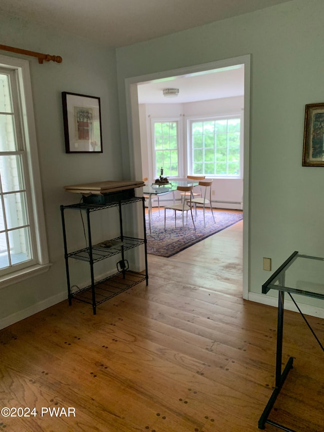 hallway with light hardwood / wood-style flooring and a baseboard radiator