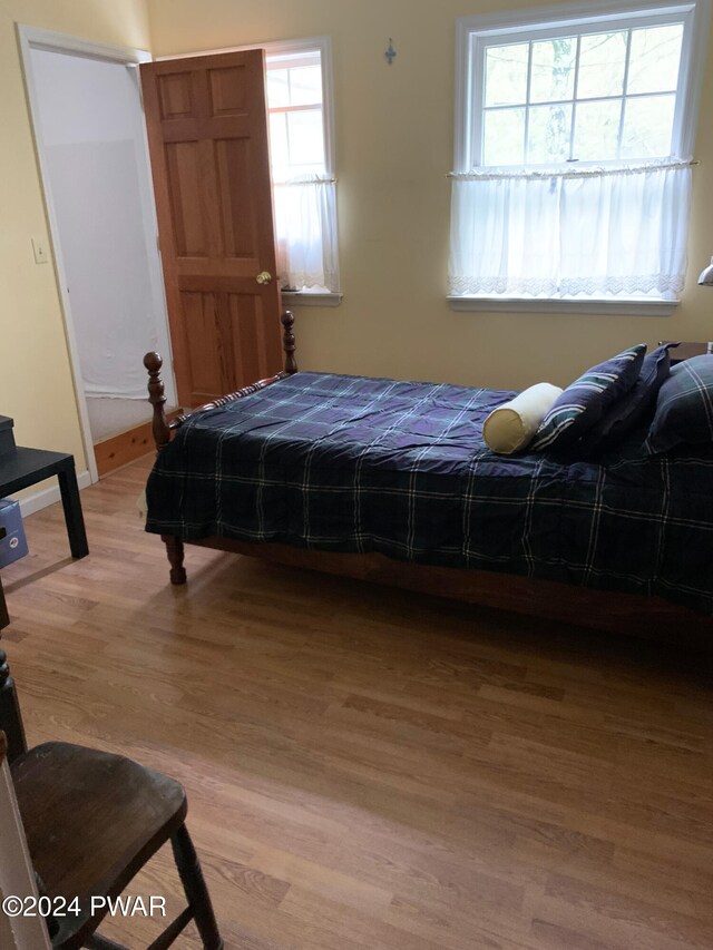 bedroom with wood-type flooring and multiple windows