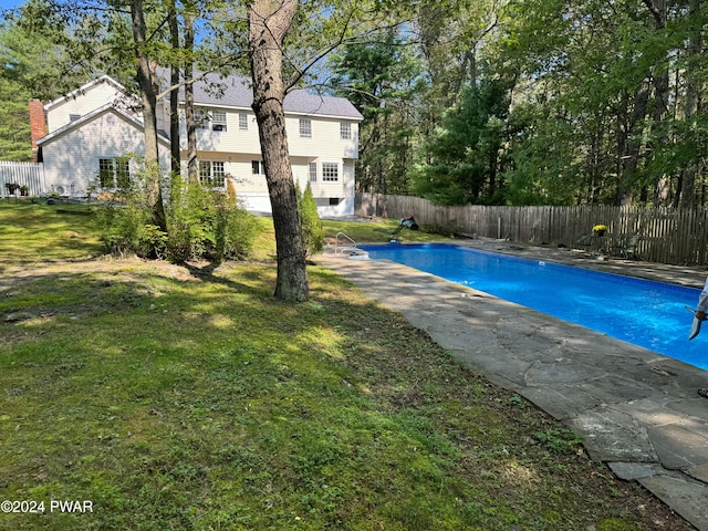 view of swimming pool with a yard