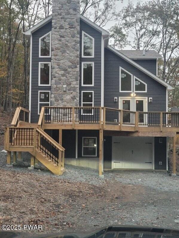 back of property featuring a garage and a wooden deck