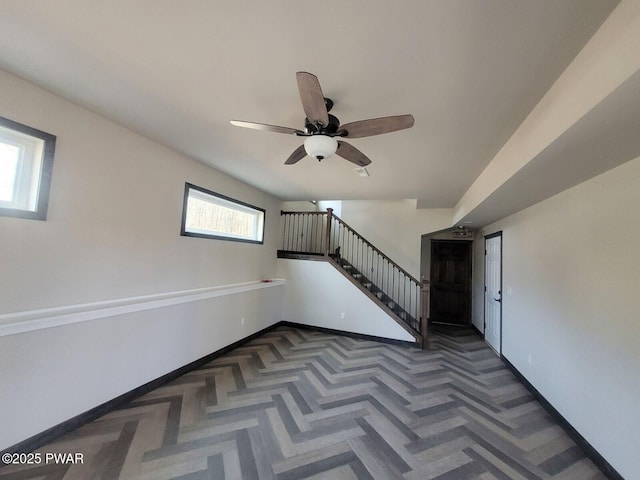 interior space with a wealth of natural light, ceiling fan, and parquet flooring