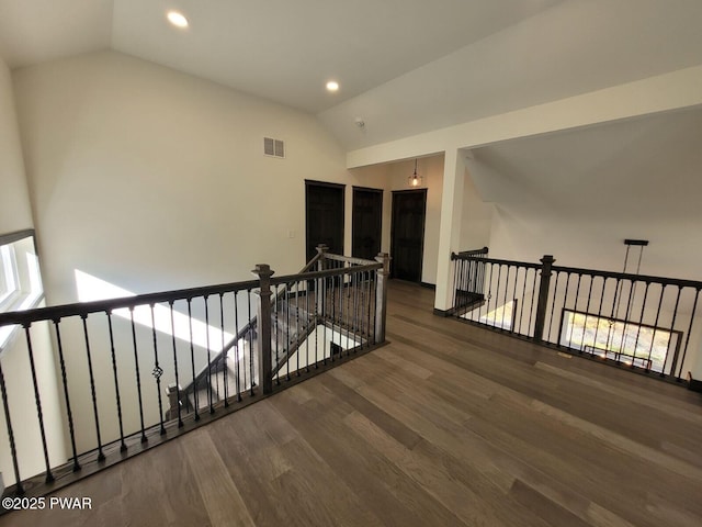 hall with dark hardwood / wood-style flooring and vaulted ceiling