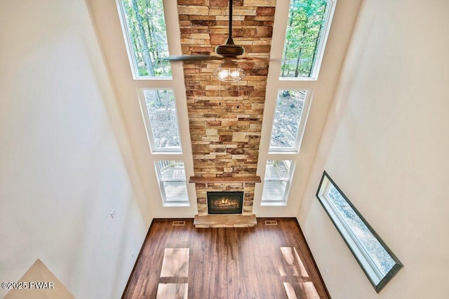 unfurnished living room with a fireplace, a high ceiling, and plenty of natural light