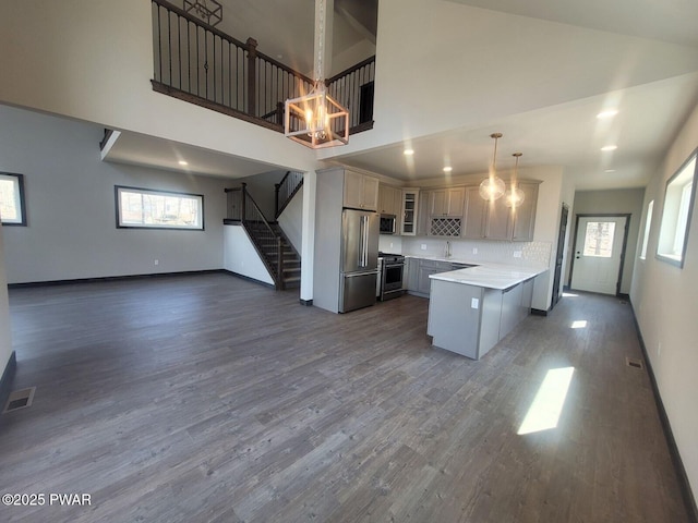 kitchen with decorative light fixtures, stainless steel appliances, dark hardwood / wood-style floors, and gray cabinetry