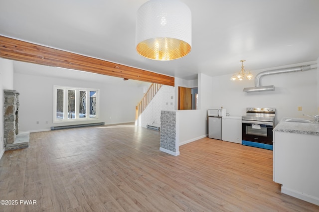 unfurnished living room featuring light wood-type flooring, a chandelier, sink, and a baseboard heating unit