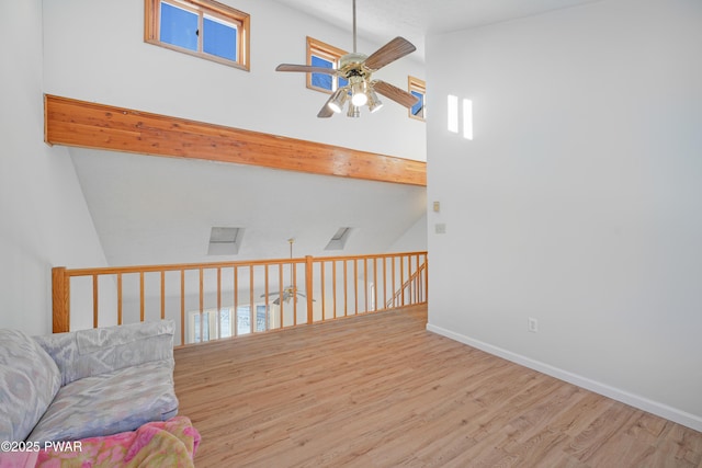 interior space featuring beamed ceiling, ceiling fan, high vaulted ceiling, and light wood-type flooring