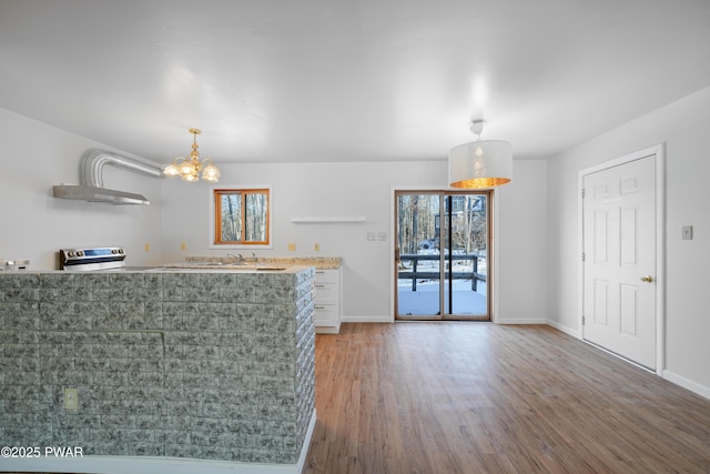 kitchen featuring hanging light fixtures, hardwood / wood-style flooring, a wealth of natural light, and white cabinets