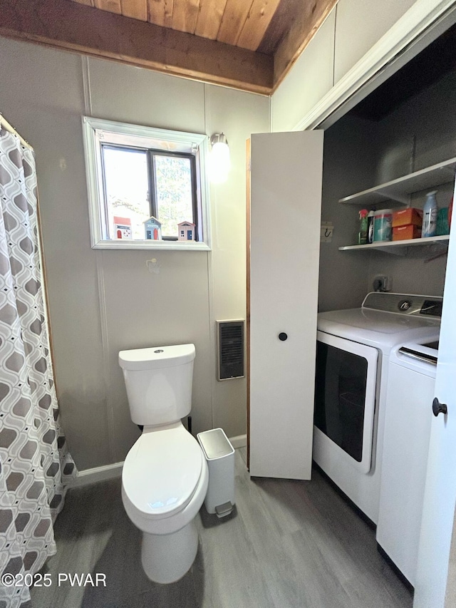 full bath featuring wood finished floors, curtained shower, washer and dryer, wooden ceiling, and toilet