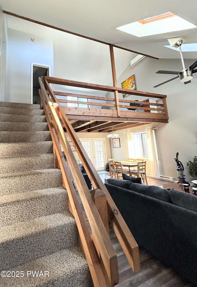 stairs with high vaulted ceiling and a ceiling fan