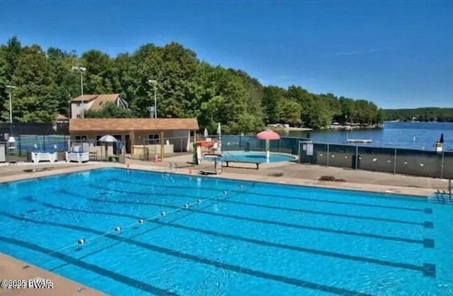 pool with a patio area and fence