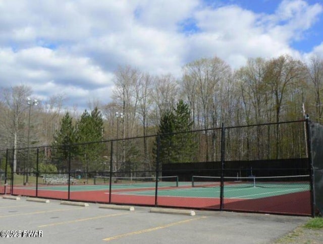 view of tennis court featuring fence