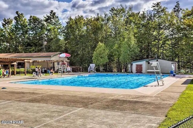 community pool featuring a patio and an outbuilding