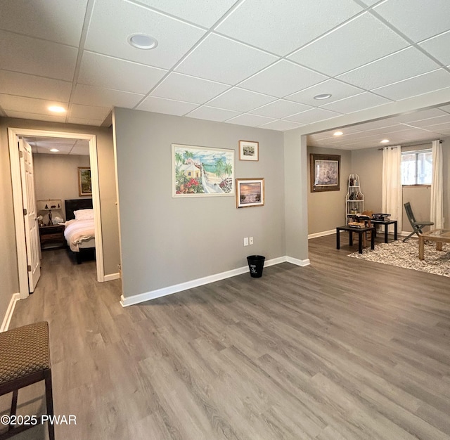 interior space with wood finished floors, baseboards, and a drop ceiling