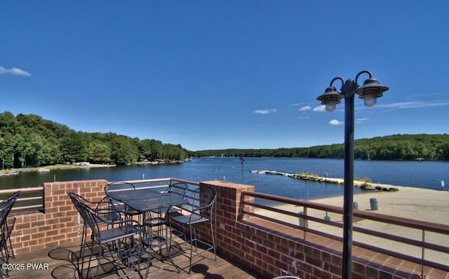 view of patio featuring a forest view and a water view