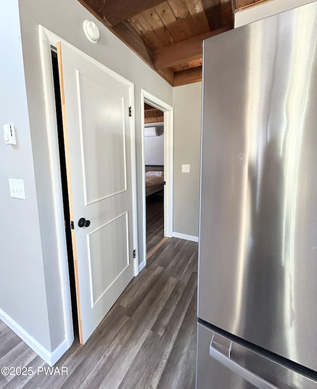 hallway featuring dark wood finished floors, beamed ceiling, wood ceiling, and baseboards