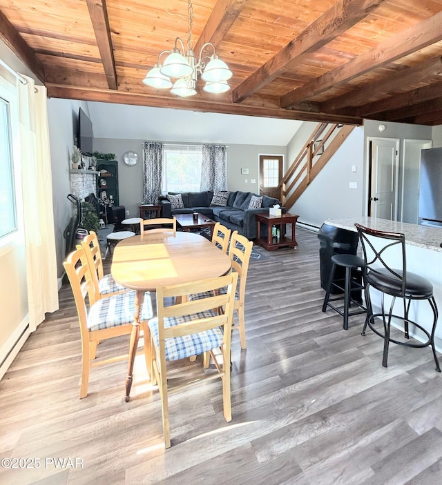 dining area featuring a chandelier, light wood-style flooring, wooden ceiling, and stairs