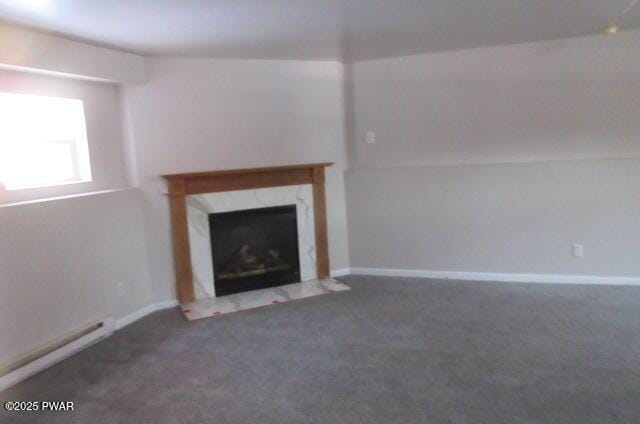 unfurnished living room with dark colored carpet and a fireplace