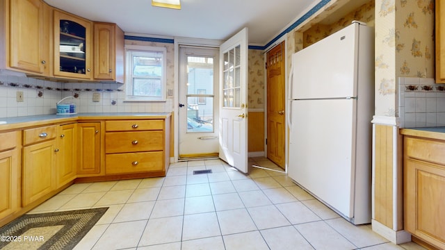 10 Kane Rd, Starlight, PA 18461 - kitchen featuring freestanding refrigerator, wallpapered walls, glass insert cabinets, light countertops, and backsplash