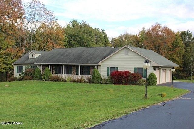 ranch-style home with aphalt driveway, a front lawn, and an attached garage