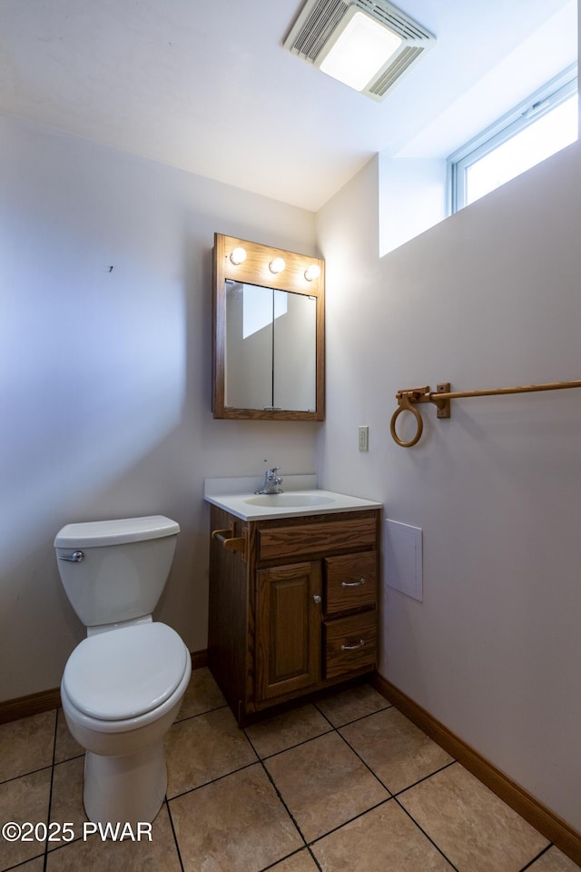 bathroom featuring toilet, vanity, visible vents, and baseboards