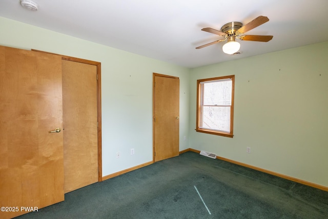 unfurnished bedroom featuring baseboards, visible vents, ceiling fan, and carpet flooring