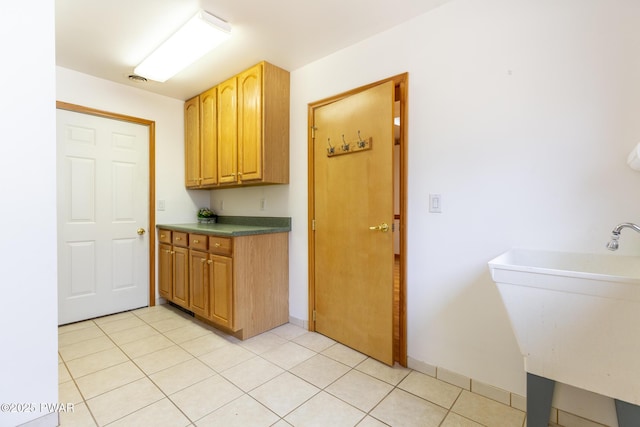 kitchen featuring a sink and light tile patterned flooring