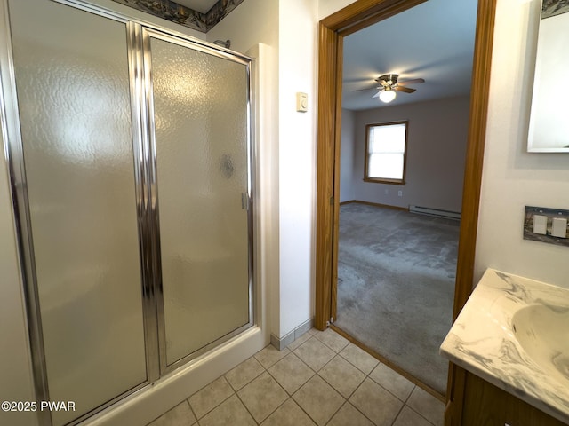 full bath with baseboard heating, a stall shower, ceiling fan, vanity, and tile patterned flooring