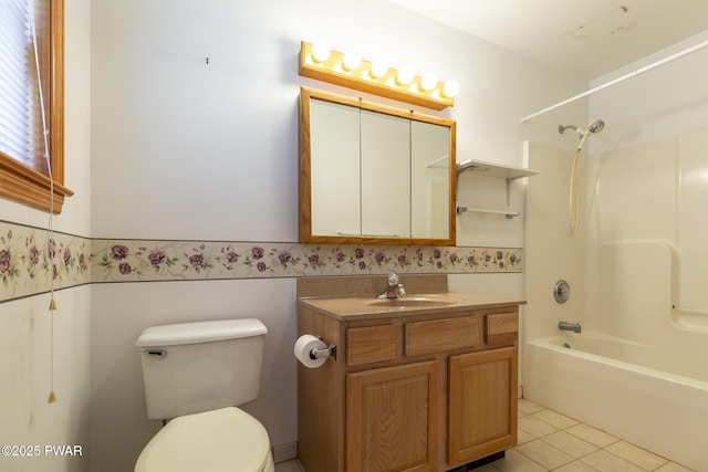 full bathroom with toilet, a wainscoted wall, shower / tub combination, tile patterned floors, and vanity