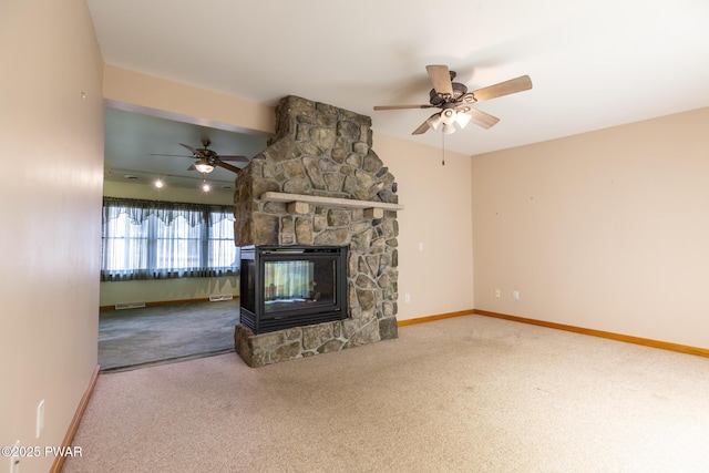 unfurnished living room featuring carpet floors, a stone fireplace, and baseboards