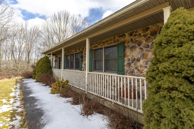 view of home's exterior with stone siding and a porch