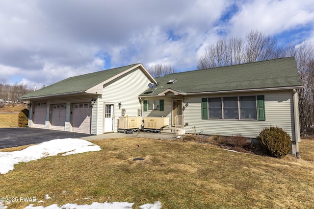 view of front of home with a garage, a front yard, driveway, and a shingled roof