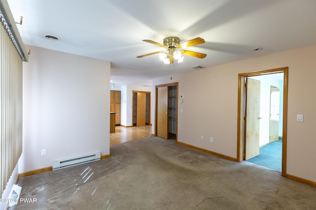 empty room with carpet floors, baseboards, visible vents, and baseboard heating