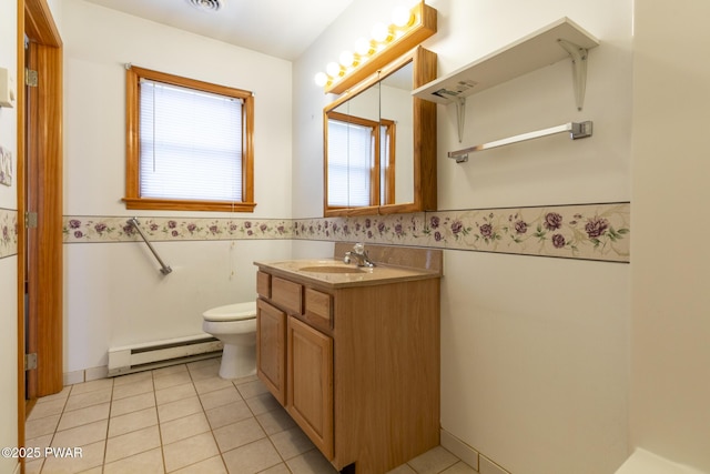 bathroom with toilet, a wainscoted wall, a baseboard heating unit, and tile patterned floors