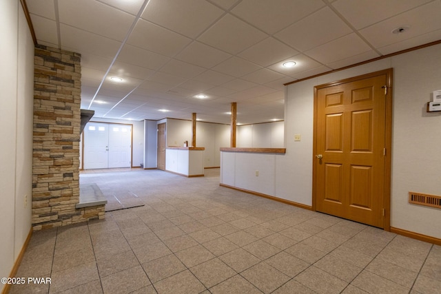 empty room with visible vents, baseboards, and a drop ceiling